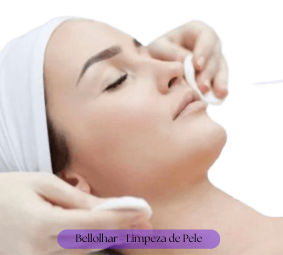 Mulher deitada numa maca, com fundo branco, usando uma toalha branca na cabeça e duas mãos limpando sua face com algodão.