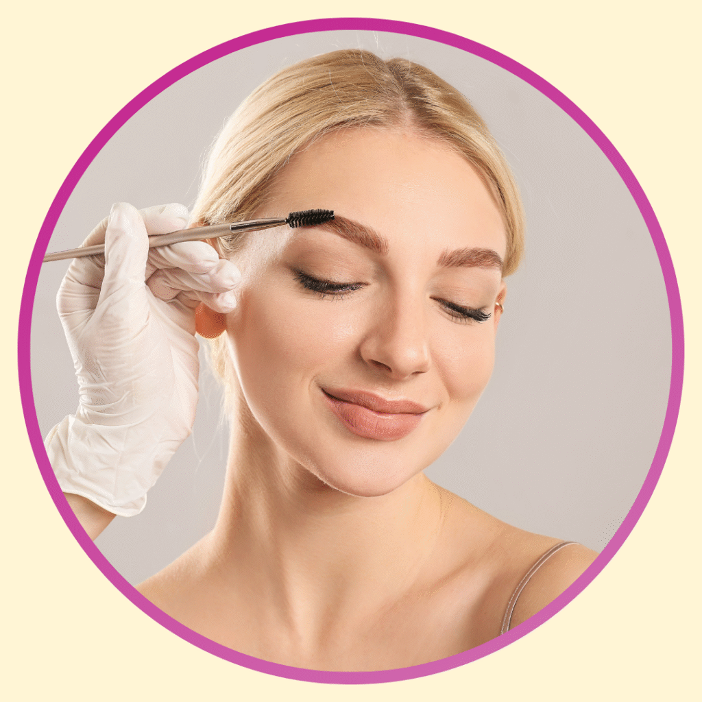 Mulher loira de cabelos presos com olhos fechados. Ao lado esquerdo uma mão com luva branca penteando as suas sobrancelhas.